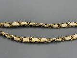 a close up of a gold chain with white beads on it