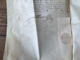un vieux bout de papier posé sur une table en bois, à côté d'une paire de ciseaux