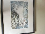 a picture hanging on the wall above a vase