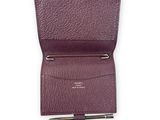 un gros plan d'un portefeuille violet contenant un stylo