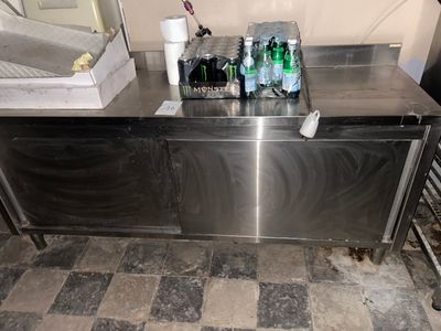 a stainless steel counter with several bottles of water on it