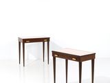 deux petites tables avec des tiroirs de chaque côté, dans une pièce blanche