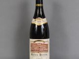 une vieille bouteille de vin posée sur une table en verre
