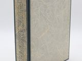 un gros plan d'un livre sur une surface blanche avec un fond blanc