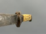 an old knife with a wooden handle on a gray background