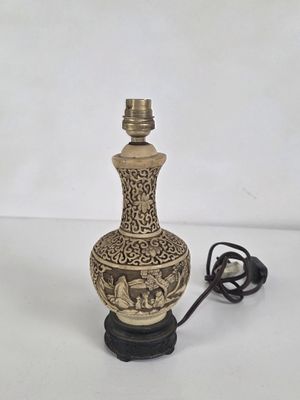 une lampe posée sur une table, avec un cordon qui y est attaché