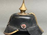 an old black helmet with a gold crown on top of a gray surface