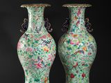 pair of chinese vases on stands on a black background
