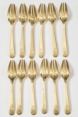 huit fourchettes et cuillères plaquées or sont disposées en rangée