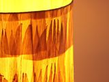 close up of a lamp with a yellow shade on a table