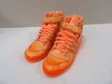 pair of orange sneakers with orange laces on a white surface