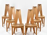 quatre chaises en bois sont alignées sur une surface blanche