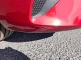 a close up of a red car ' s front bumper