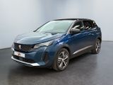 Une voiture bleue est garée dans une pièce au sol noir.