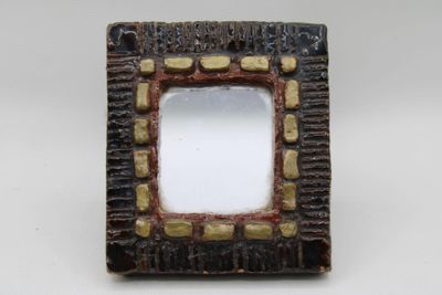 a picture of a small square mirror on a table