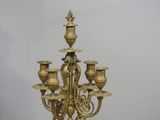 a gold colored chandelier that has five candles on it