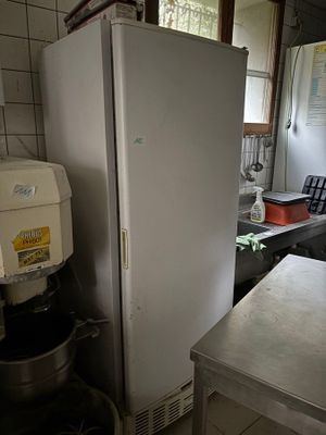 un réfrigérateur blanc dans une cuisine, à côté d'un plan de travail