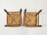 two wooden chairs with wooden arms and legs on a white surface
