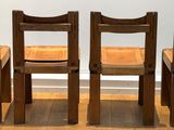 four wooden chairs sitting next to each other on a wooden floor