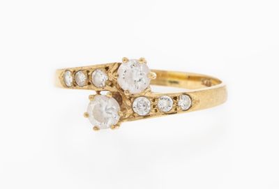 an image of a gold ring with three white stones