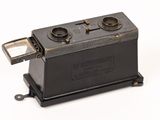 an old camera that is sitting on a white surface