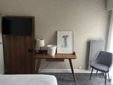 a picture of a bedroom with a desk, chair, and television