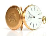 a gold pocket watch with roman numerals on it