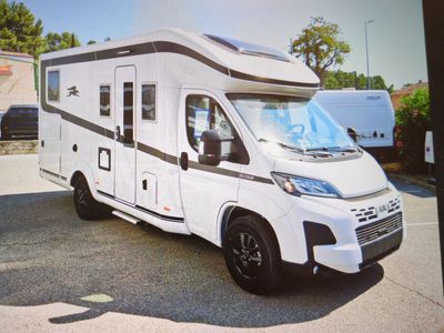 une photo d'un camping-car garé sur un parking