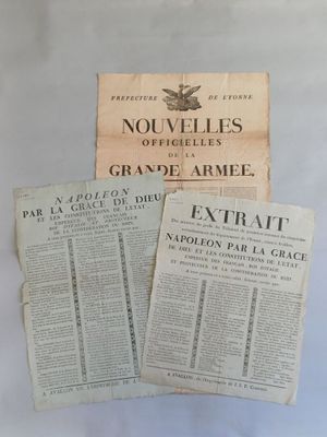 three old french newspapers sitting on top of a white table