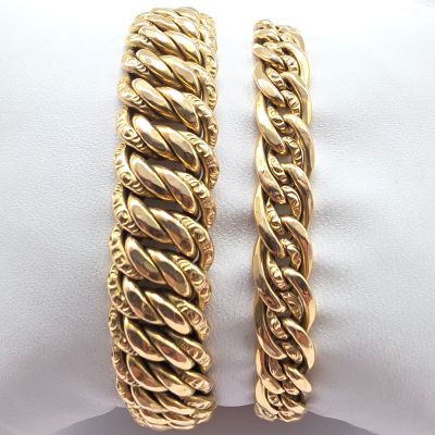 a close up of two gold bracelets on a white napkin