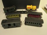cinq petits trains miniatures posés les uns à côté des autres sur une table