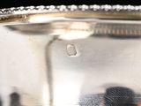a silver plate with a silver handle on a table