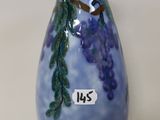 a blue vase with purple grapes painted on it