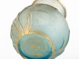 a blue glass vase with a gold rim on a white surface
