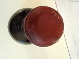 a close up of a red and black knob on a white table
