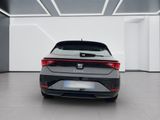 the rear end of a grey car in a white room