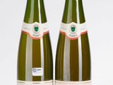 deux bouteilles de vin posées l'une à côté de l'autre sur une surface blanche