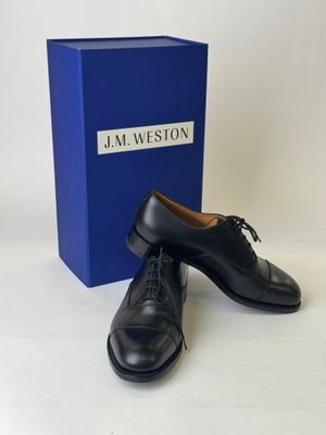 the black shoes are next to a blue box on a white surface