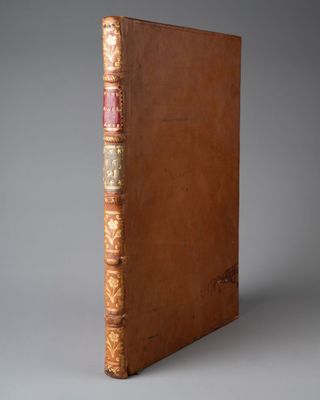 un vieux livre à la couverture brune posé sur une table