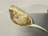 a spoon that has a small piece of food on it