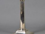 an antique silver plated candle holder sitting on a table