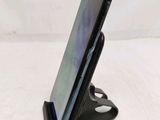 a close up of a cell phone on a stand on a table
