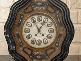 a clock that is sitting on a table in front of a brick wall