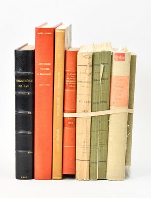 several old books are stacked on top of each other on a white surface