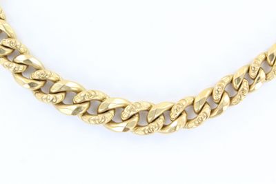 un collier à chaîne en or sur fond blanc