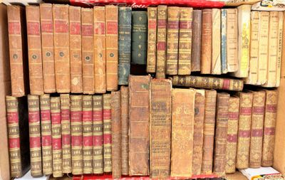 many old books stacked on top of each other in a box