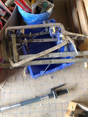 un tas d'outils par terre, à côté d'un seau bleu