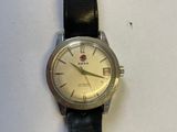 une photo d'une montre-bracelet posée sur une surface blanche