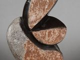 a sculpture of a bird made of stone on a gray surface