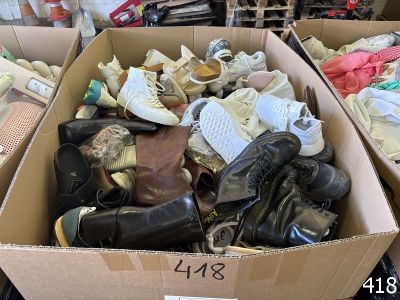 many pairs of shoes in a cardboard box on the floor